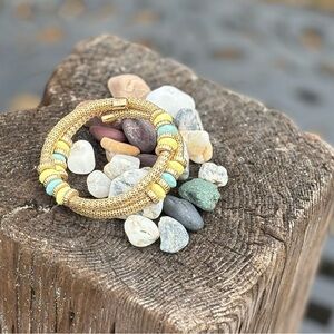 Adjustable bracelet in gold tone with yellow and green beads.